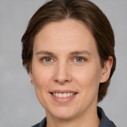 Joyful white adult female with medium  brown hair and grey eyes