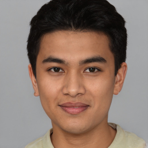 Joyful latino young-adult male with short  black hair and brown eyes