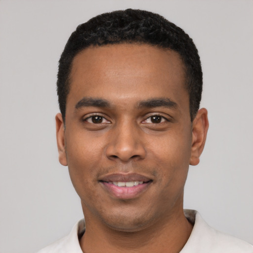Joyful black young-adult male with short  black hair and brown eyes