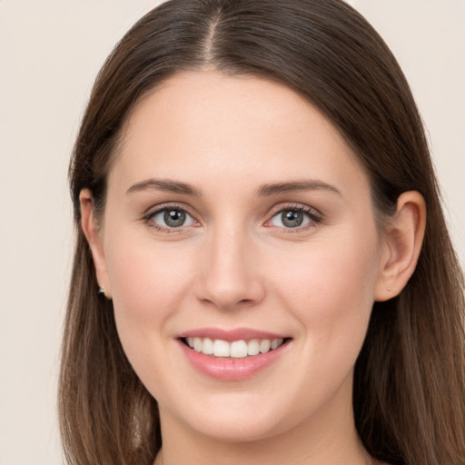 Joyful white young-adult female with long  brown hair and grey eyes