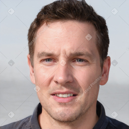 Joyful white adult male with short  brown hair and grey eyes