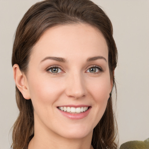 Joyful white young-adult female with medium  brown hair and grey eyes