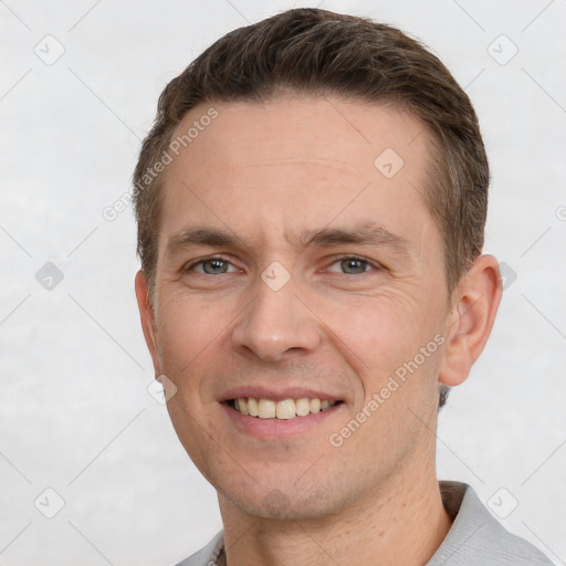 Joyful white young-adult male with short  brown hair and grey eyes