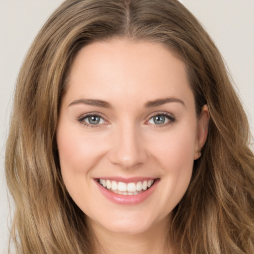 Joyful white young-adult female with long  brown hair and green eyes