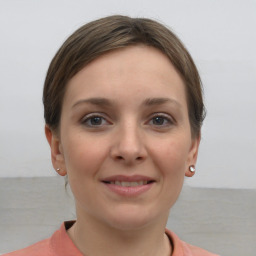 Joyful white young-adult female with short  brown hair and grey eyes