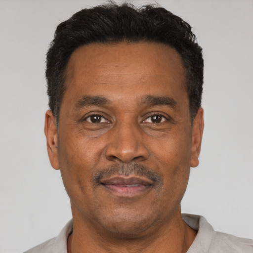 Joyful latino adult male with short  black hair and brown eyes