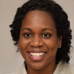 Joyful black adult female with long  brown hair and brown eyes