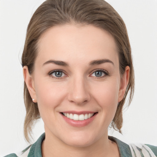 Joyful white young-adult female with medium  brown hair and grey eyes