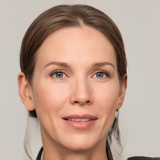 Joyful white adult female with medium  brown hair and grey eyes