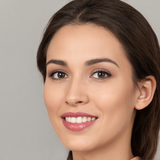 Joyful white young-adult female with long  brown hair and brown eyes