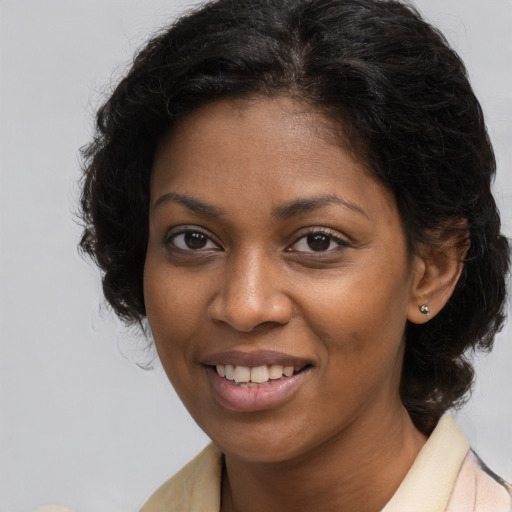 Joyful black young-adult female with long  brown hair and brown eyes
