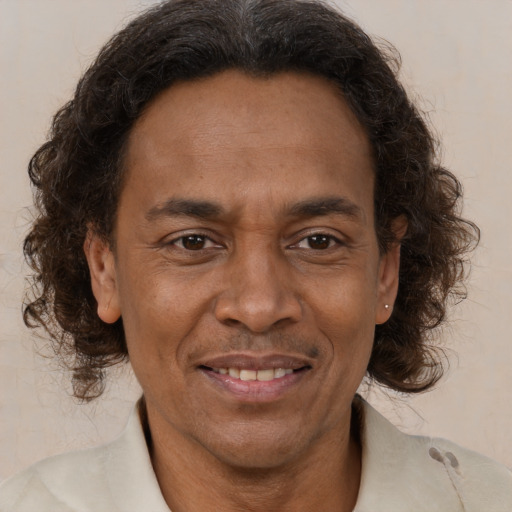 Joyful black adult male with medium  brown hair and brown eyes