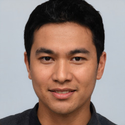 Joyful asian young-adult male with short  black hair and brown eyes