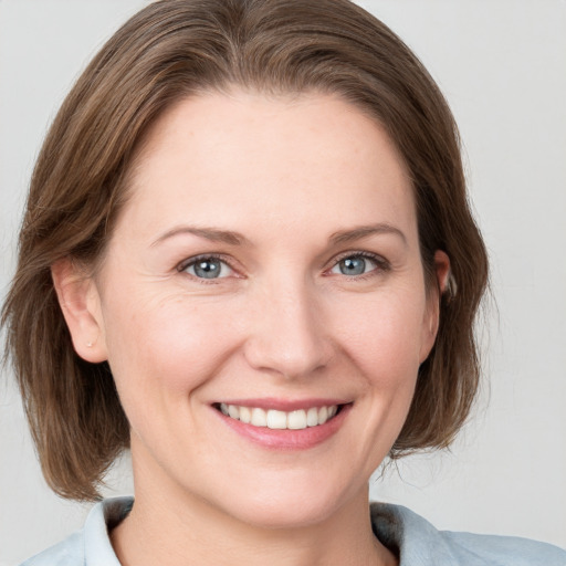 Joyful white young-adult female with medium  brown hair and blue eyes