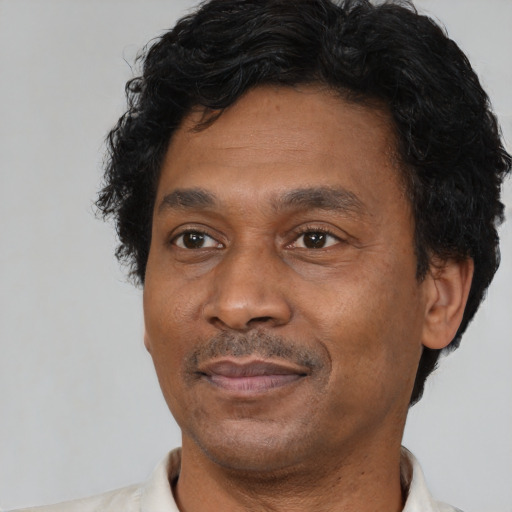 Joyful latino adult male with short  black hair and brown eyes