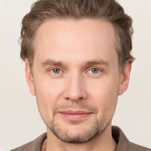 Joyful white adult male with short  brown hair and grey eyes