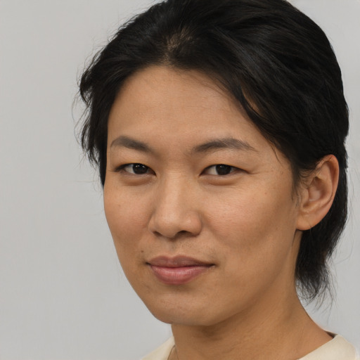 Joyful asian adult female with medium  brown hair and brown eyes