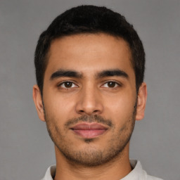 Joyful latino young-adult male with short  brown hair and brown eyes