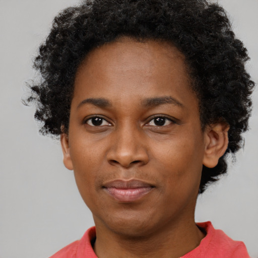 Joyful black young-adult female with short  black hair and brown eyes