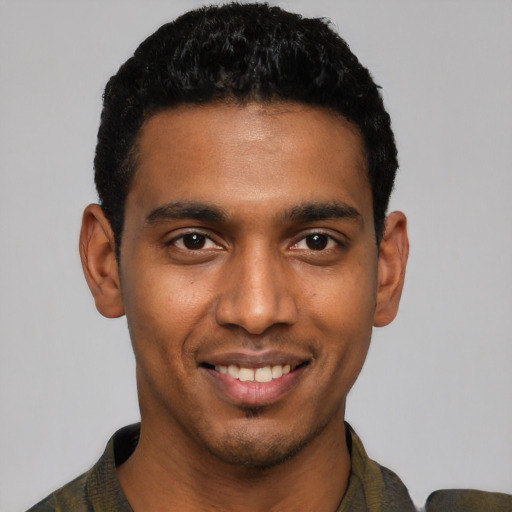 Joyful black young-adult male with short  black hair and brown eyes
