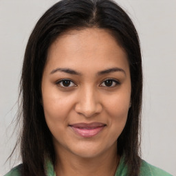 Joyful latino young-adult female with long  brown hair and brown eyes