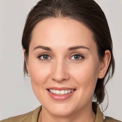 Joyful white young-adult female with medium  brown hair and grey eyes