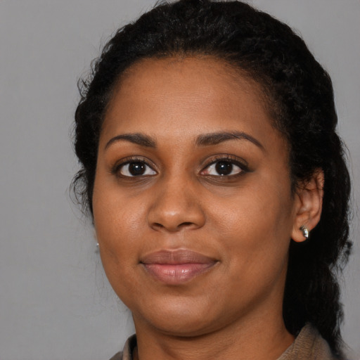 Joyful black young-adult female with long  brown hair and brown eyes