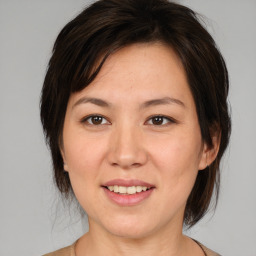 Joyful white adult female with medium  brown hair and brown eyes