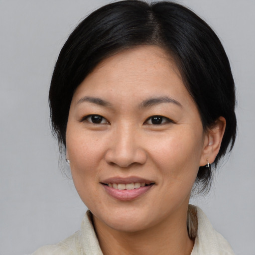 Joyful asian adult female with medium  brown hair and brown eyes