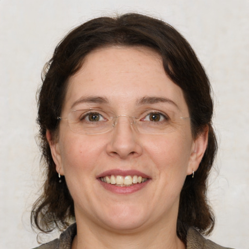 Joyful white adult female with medium  brown hair and grey eyes