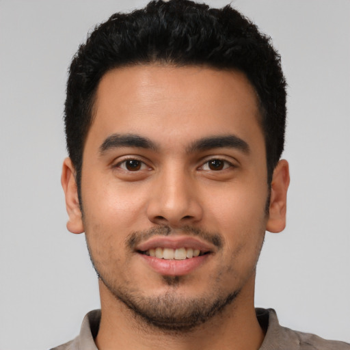 Joyful latino young-adult male with short  brown hair and brown eyes