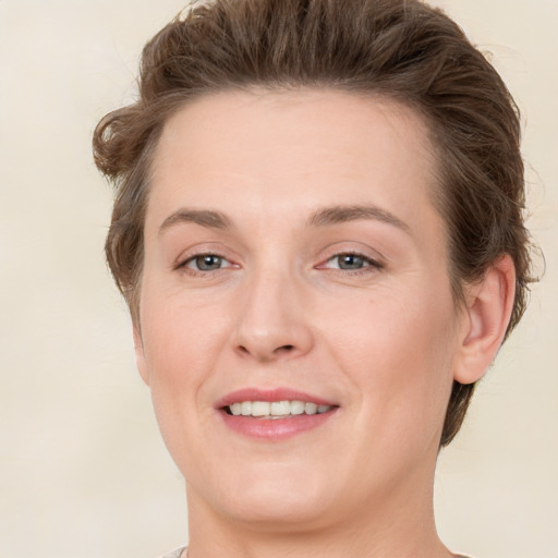 Joyful white young-adult female with medium  brown hair and green eyes