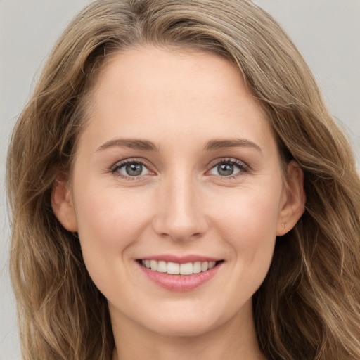 Joyful white young-adult female with long  brown hair and grey eyes