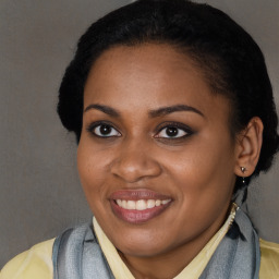 Joyful black young-adult female with long  brown hair and brown eyes