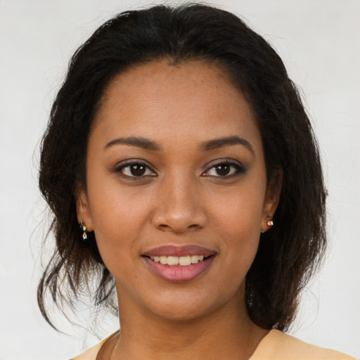 Joyful black young-adult female with medium  brown hair and brown eyes