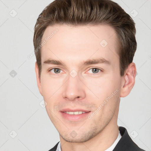 Joyful white young-adult male with short  brown hair and grey eyes