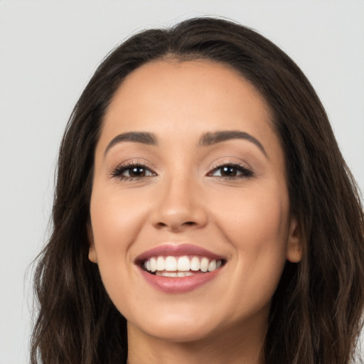 Joyful white young-adult female with long  brown hair and brown eyes