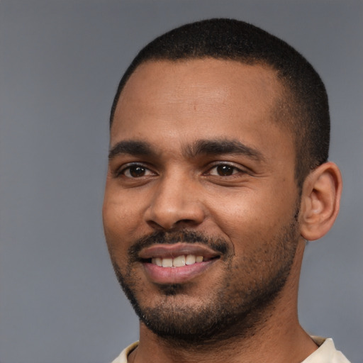 Joyful black young-adult male with short  black hair and brown eyes