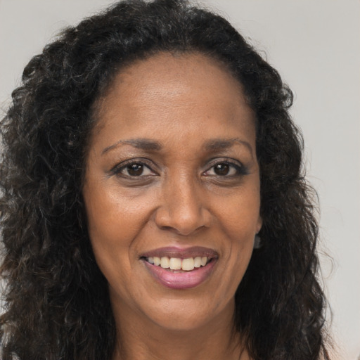 Joyful black adult female with long  brown hair and brown eyes