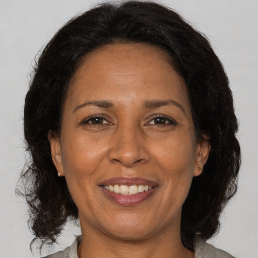 Joyful black adult female with medium  brown hair and brown eyes