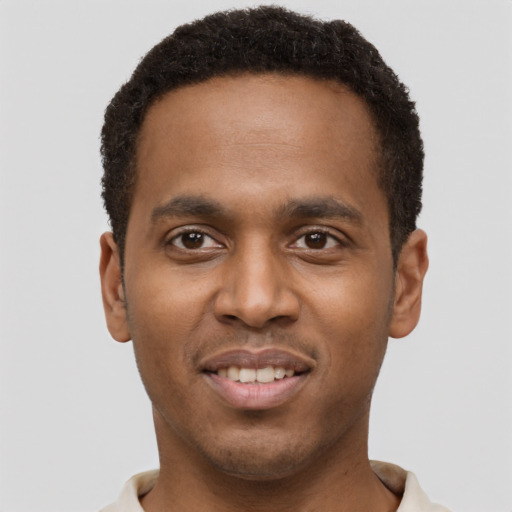 Joyful black young-adult male with short  brown hair and brown eyes