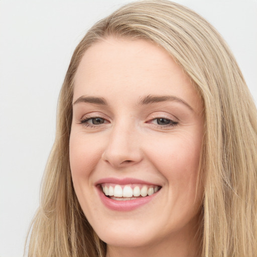 Joyful white young-adult female with long  brown hair and blue eyes