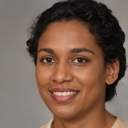 Joyful black young-adult female with medium  brown hair and brown eyes