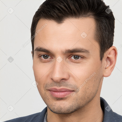 Joyful white young-adult male with short  brown hair and brown eyes