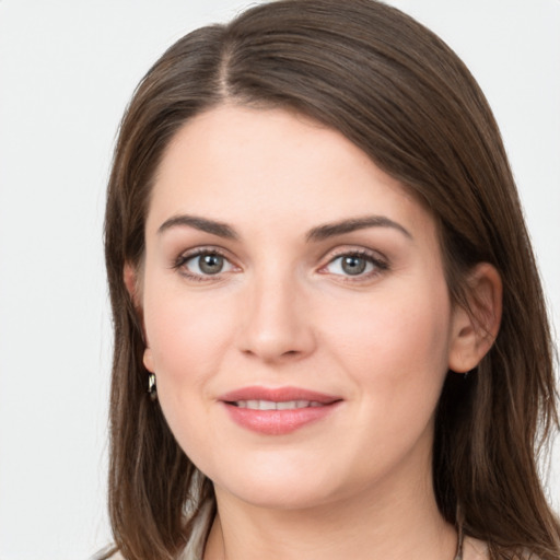 Joyful white young-adult female with long  brown hair and grey eyes