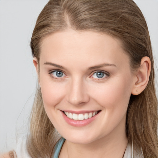 Joyful white young-adult female with long  brown hair and blue eyes