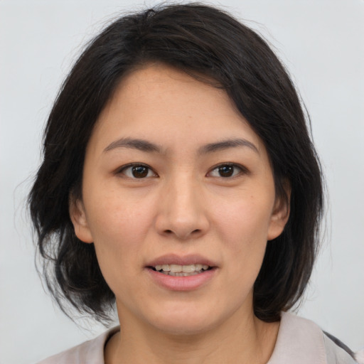 Joyful asian young-adult female with medium  brown hair and brown eyes