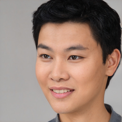 Joyful asian young-adult male with short  black hair and brown eyes