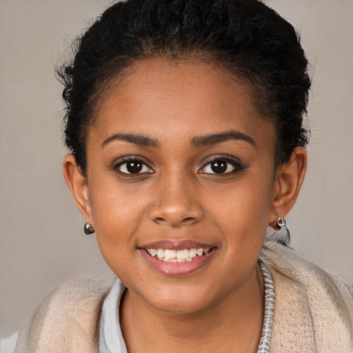 Joyful black young-adult female with short  brown hair and brown eyes