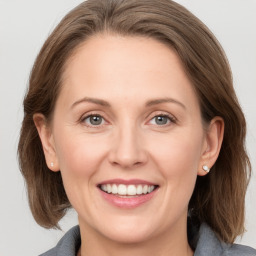 Joyful white adult female with medium  brown hair and grey eyes